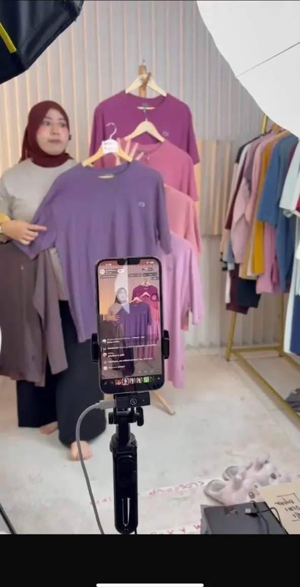 Fashion livestream set with a clothing rail and phone on a tripod